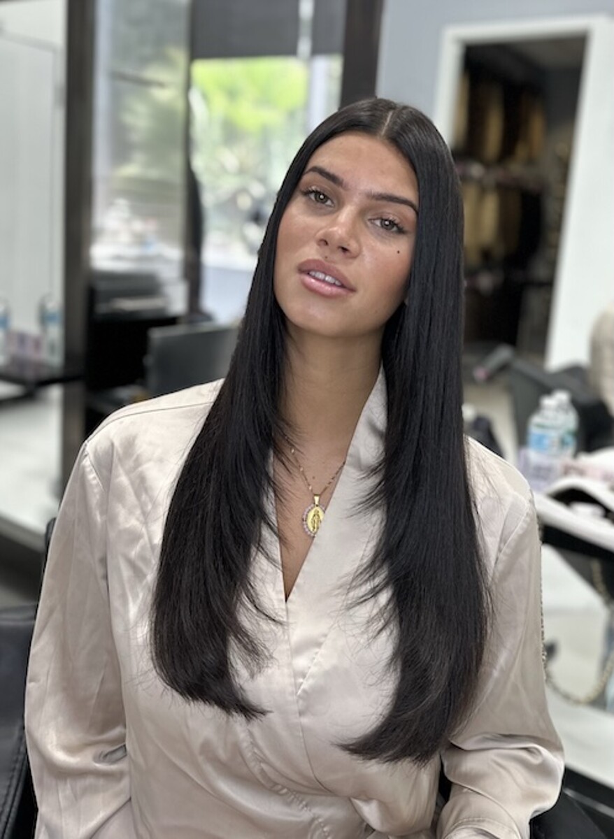 Status Hair client with healthy, shiny extensions in soft waves